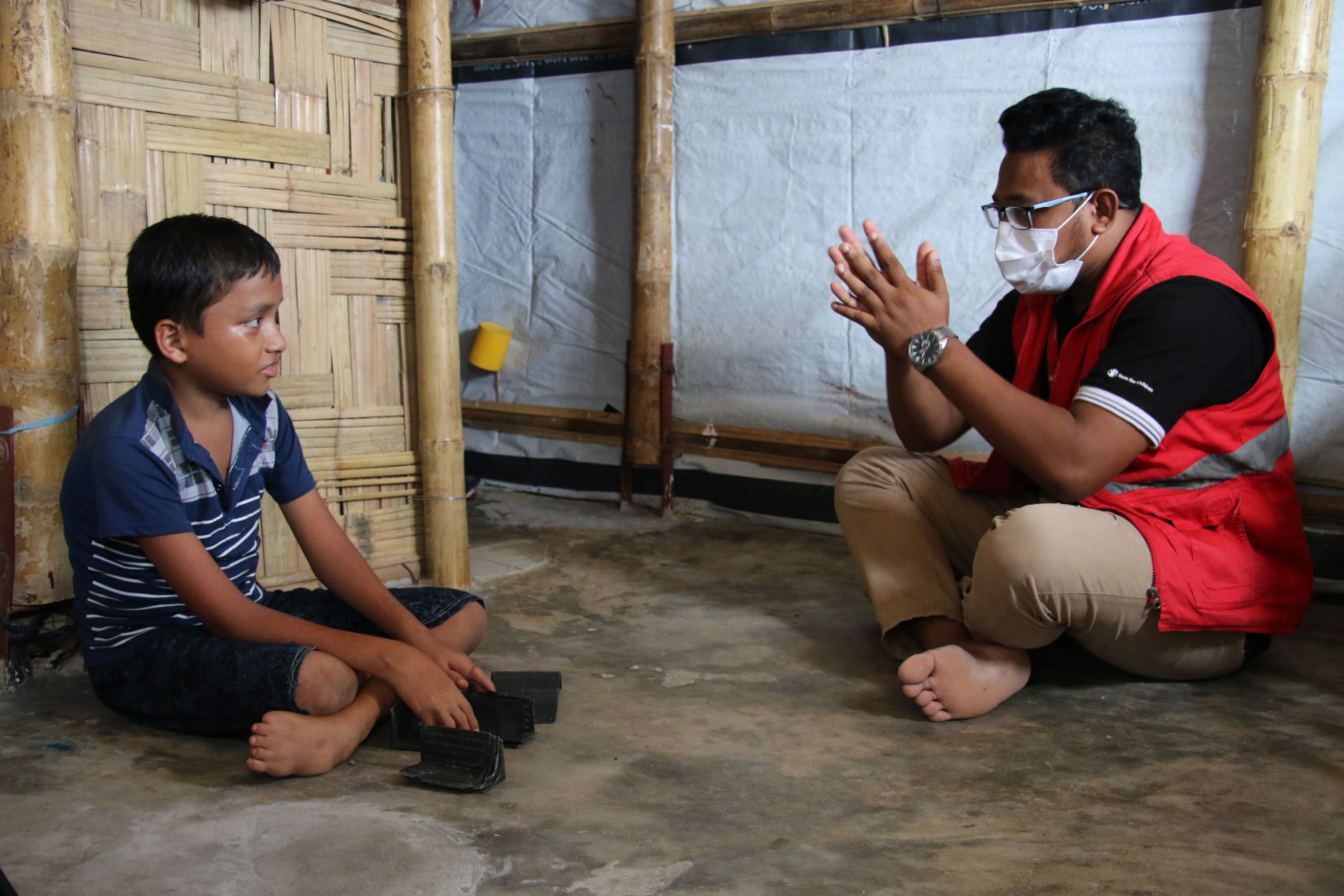 Banna*, 11, speaks with Save the Children Case Worker Mostafa Mahmudul Haque Akib